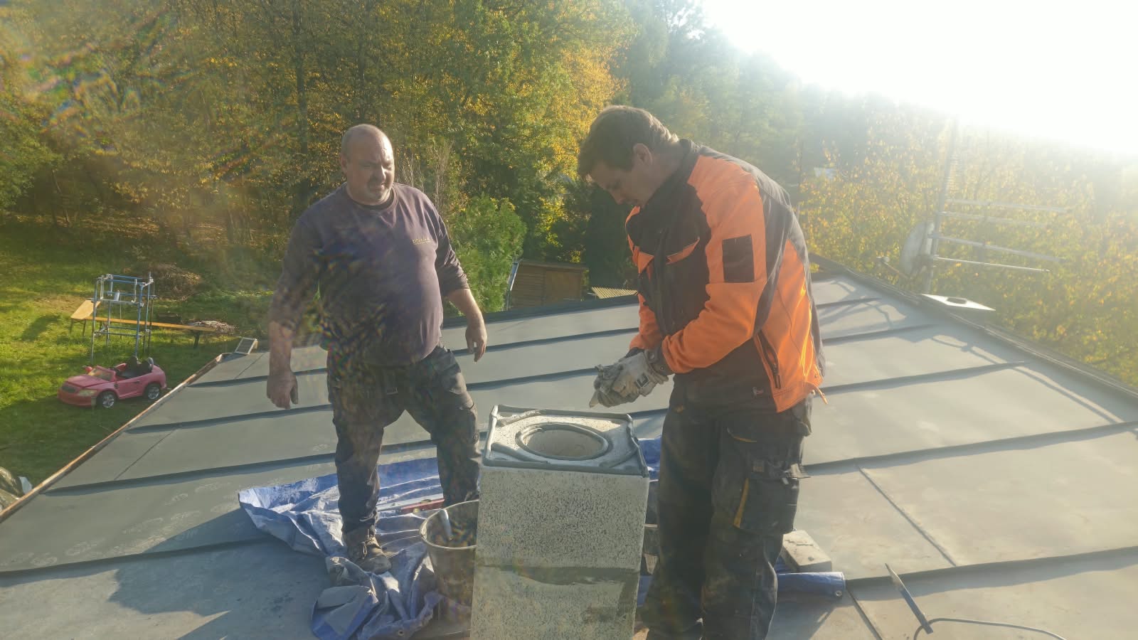 Kominíci u rozestavěného komína na střeše rodinného domu