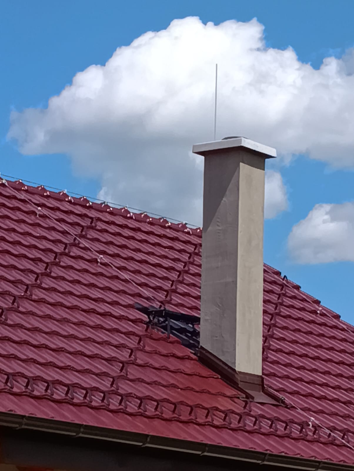 Nový zděný komín s betonovou krycí deskou nad taškovou střechou